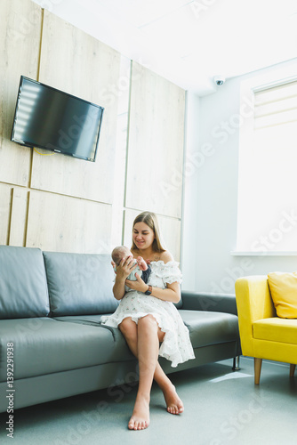 Obraz na płótnie A heartwarming moment of bonding between a mother and her baby is captured beautifully within a modern interior setting, showcasing their affectionate relationship, filled with love and joy w salonie