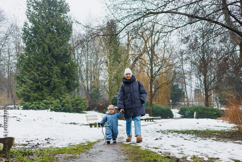 Obraz na płótnie Enjoying a delightful family winter walk especially capturing the immense joy that parenting brings while exploring a beautiful snowy landscape with a precious child at your side w salonie