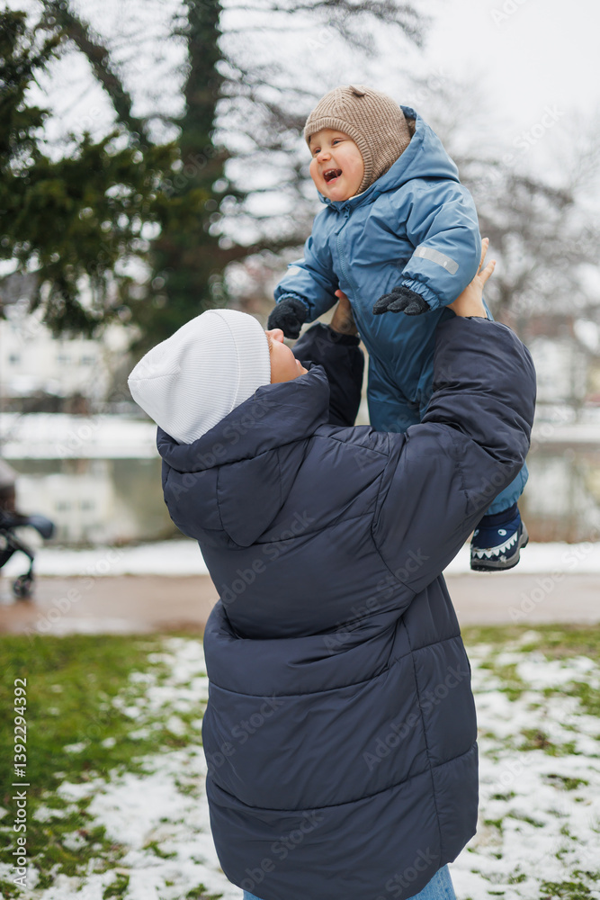 Embracing Joyful Playtime During the Winter Season A Loving, Caring Parent Joyfully Lifting Their Thriving and Happy Child Outdoors for Delightful Fun and Bundles of Laughter and Happiness