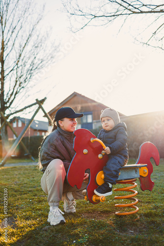A Joyful Afternoon at the Park A Mother and Her Child Enjoying Playtime on a Spring Rider, Embracing Moments of Happiness and Bonding in a Colorful Playground Surrounded by Nature