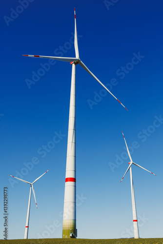 Obraz na płótnie Wind turbines generating energy against a clear blue sky. Wind turbines generating clean renewable energy for sustainable development w salonie