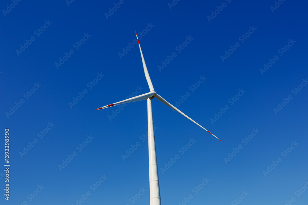 Wind turbines generating energy against a clear blue sky. Wind turbines generating clean renewable energy for sustainable development