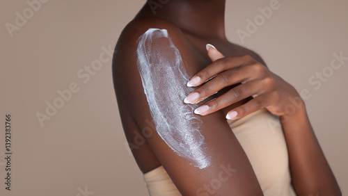 Body skin care treatment. Close up photo of a woman applying a moisturizing and hydration lotion on her shoulder.
