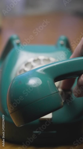 Man dials contact number on vintage telephone then hangs up receiver VERTICAL