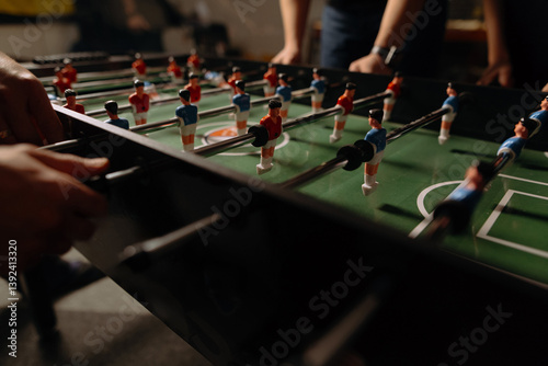 A vibrant foosball table captures intense gameplay, with players engaged in a friendly competition, showcasing their skills and strategy. photo