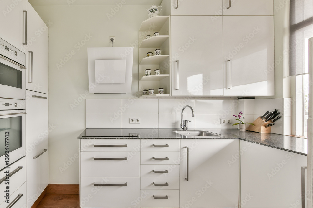 Fototapeta premium A stylish modern kitchen featuring minimalist cabinets, a sleek countertop, and organized shelves, creating an inviting cooking space.
