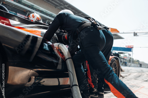 Team Mechanics Changing Tires and refuel During a High-Speed Pit Stop in the Midst of an Endurance Race