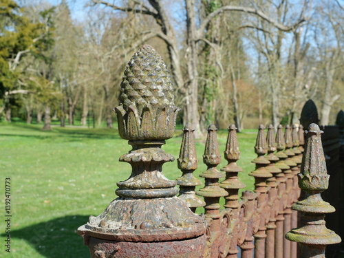 Cast iron pine cone as a striking post crowning a historic fence in a park with princely origins. photo