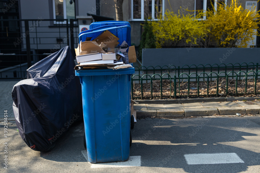 A blue recycling trash bin labeled