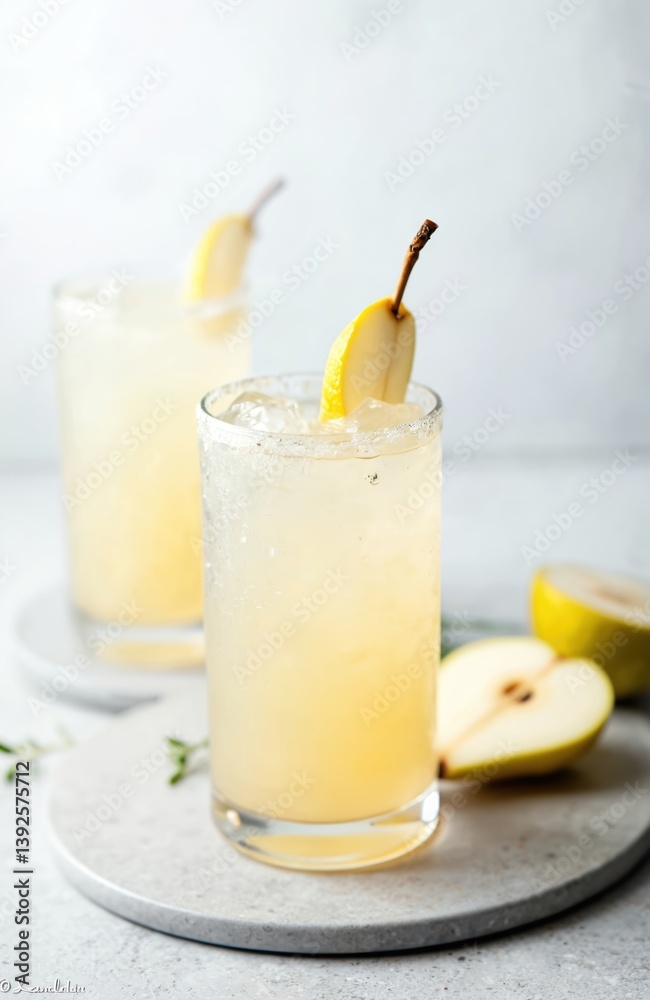 Fototapeta premium Refreshing pear soda water mocktail cocktail in glass, gray concrete background. Non alcoholic summer drink with pear slices, ice. Vertical orientation, copy space. Perfect for cafe, restaurant, bar