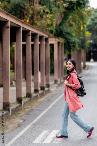 Young student walking on pedestrian crossing near university campus