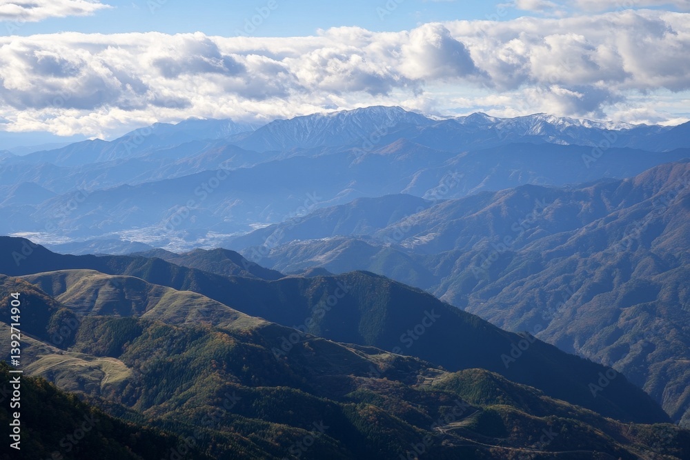 Fototapeta premium Mountain range view with blue skies and clouds above peaks