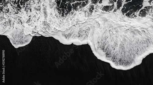 Ocean's Embrace: An aerial view captures the powerful dance of ocean waves meeting a dark shore, rendered in dramatic grayscale. A study in contrasts.