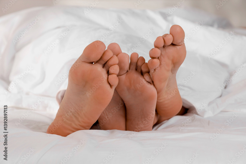 Couple lying in bed with white sheets, closeup Couple lying in bed with white sheets, closeup