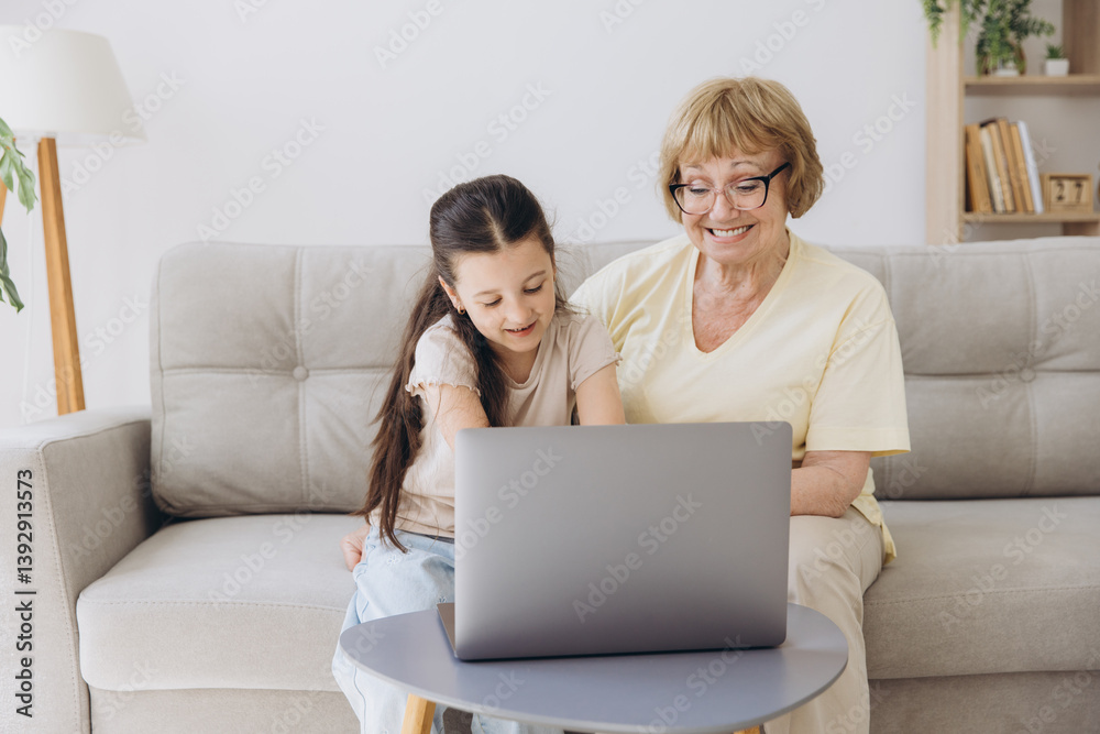 Multi generational family, grandma and granddaughter sit on couch with wireless computer, look at each other with tenderness and love, enjoy leisure on internet and time together, watch on-line movies Multi generational family, grandma and granddaughter sit on couch with wireless computer, look at each other with tenderness and love, enjoy leisure on internet and time together, watch on-line movies