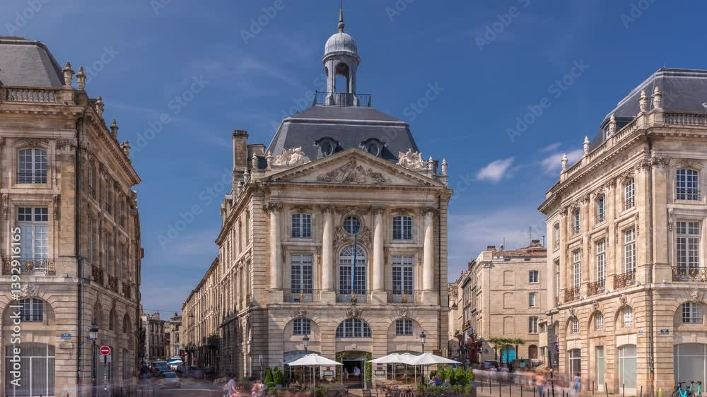 Place de la Bourse timelapse hyperlapse in Bordeaux, France, with restaurants surrounded by classic architecture under a cloudy blue sky. People walking around the main square and central streets