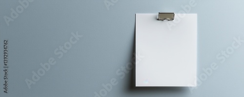 A clean, minimalist clipboard with a blank sheet attached, set against a textured blue wall, creating a professional and modern aesthetic.