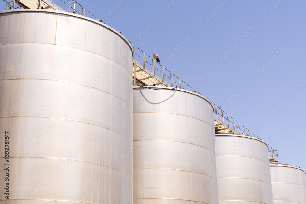 Metal tanks used for winemaking in a Sicilian winery on a clear day Metal tanks used for winemaking in a Sicilian winery on a clear day