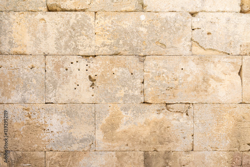 Old beige limestone wall forming a textured background
