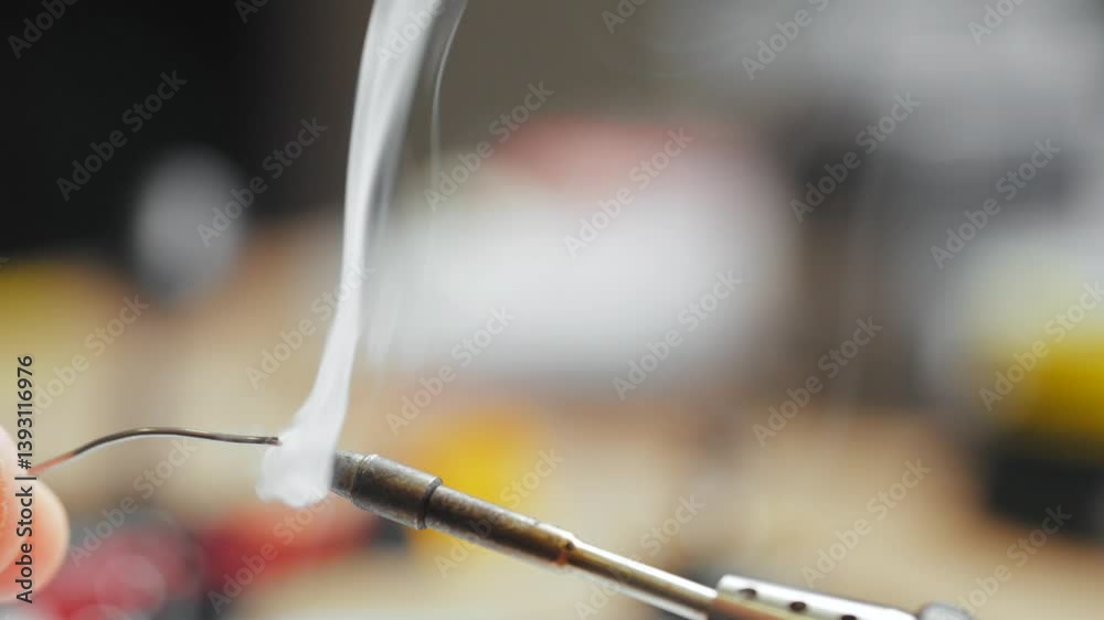 A Heated Soldering Iron Tip Coated with Rosin for Solder, Emitting Smoke. A Heated Soldering Iron Tip Coated with Rosin for Solder, Emitting Smoke.