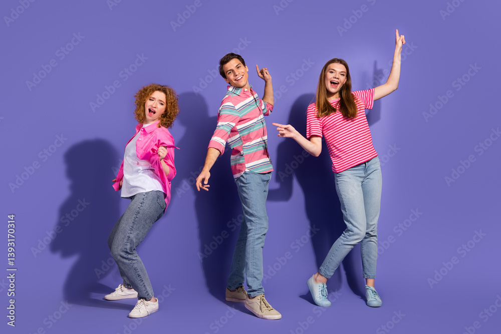 Fototapeta premium Group of young friends posing together with upbeat expressions and colorful outfits on a purple background