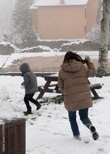 Child with his mother playing in the snow