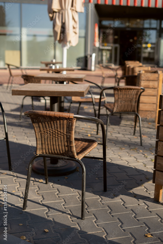 photo Outdoor seating area with wicker chairs and wooden tables under umbrellas at a sunlit pavement cafe for a relaxing restaurant dining experience photo Outdoor seating area with wicker chairs and wooden tables under umbrellas at a sunlit pavement cafe for a relaxing restaurant dining experience