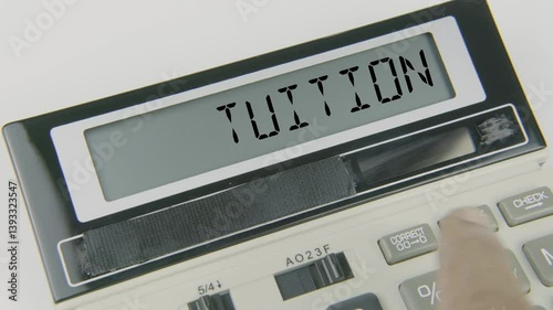 Tuition text displayed on a calculator’s LED screen as a hand types numbers, symbolizing the cost of education, budgeting for school or college fees, and financial planning for academic expenses