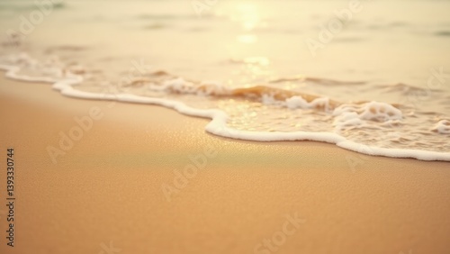 Close-up view of the shoreline where soft ocean waves meet fine golden sand. Gentle ripples and natural textures create a calm, minimalist beach scene.