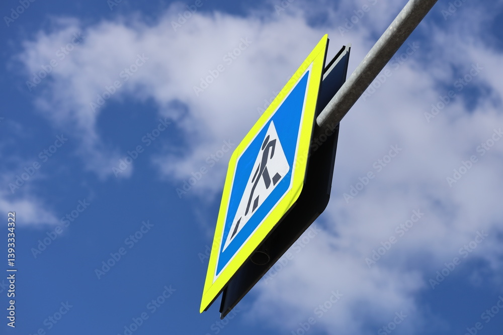 A blue and yellow street sign attached to a metal pole, suitable for urban scenes or navigation.