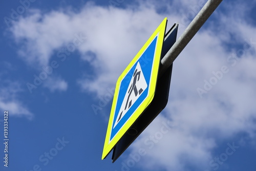Obraz na płótnie A blue and yellow street sign attached to a metal pole, suitable for urban scenes or navigation. w salonie