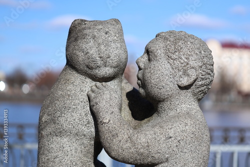Obraz na płótnie Sculpture of two kids embracing, a symbol of love and affection. w salonie