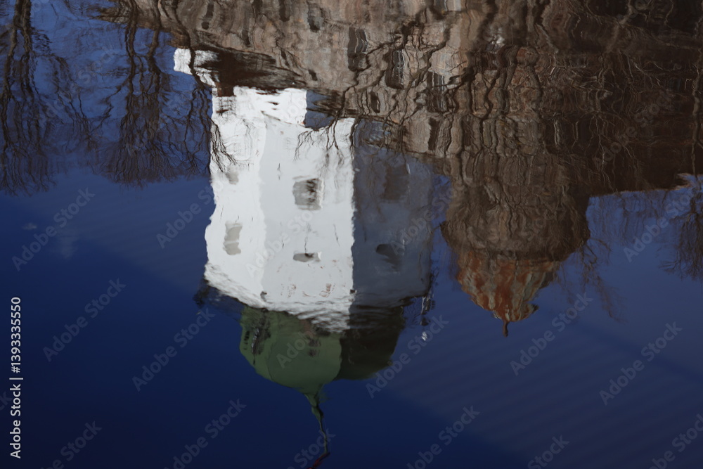 A building reflected in the calm water.