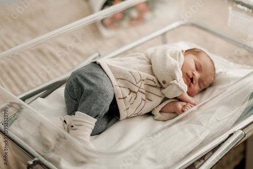 Foto A newborn baby sleeping peacefully in a hospital bassinet, wearing a cozy outfit