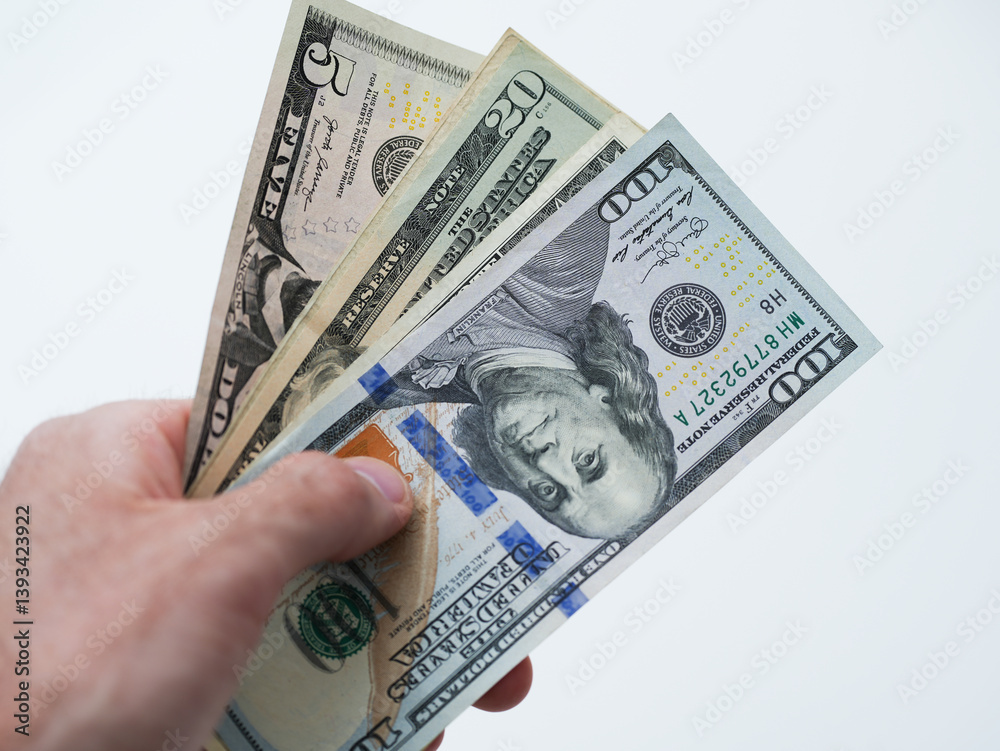 A man's hand holding stack of dollar bills against white background. Shot conveys financial success, cash transactions or business deals. Perfect for banking ads, investment projects and business A man's hand holding stack of dollar bills against white background. Shot conveys financial success, cash transactions or business deals. Perfect for banking ads, investment projects and business