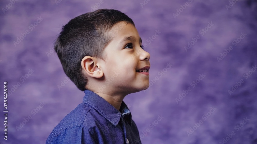 A young boy wearing a blue shirt and tie, possibly for a formal occasion or special event