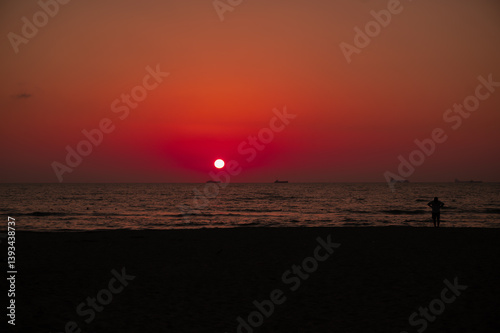 Scenic sunset over the sea in Albania. Vibrant sky with warm orange and pink hues reflecting on the calm water. 
