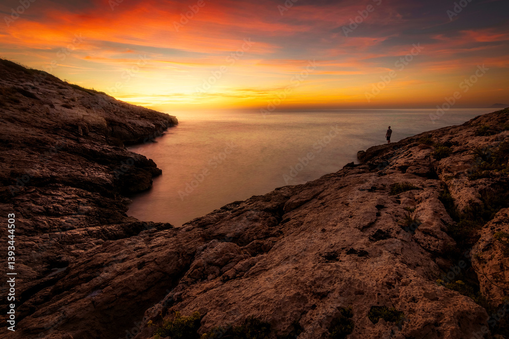 Fototapeta premium dramatic coastal landscape with colorful dramatic sky with person