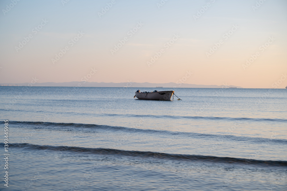 A single boat floating quietly in the open sea under a clear sky. Minimalist seascape with calm water and a peaceful atmosphere.