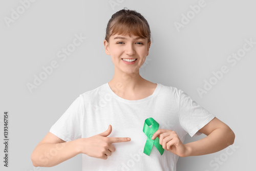 Young woman pointing at gre...