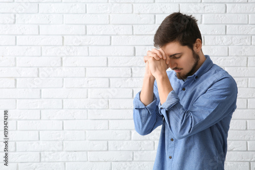 Young man praying on white ...
