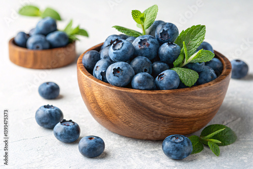 A rustic wooden bowl overflowing with plump, juicy blueberries, adorned with fresh mint sprigs, a summer harvest scene of vibrant freshness and natural goodness.