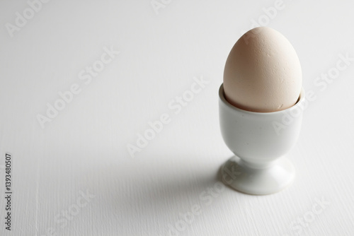 Minimalist Egg Presentation with Ceramic Cup on White Surface