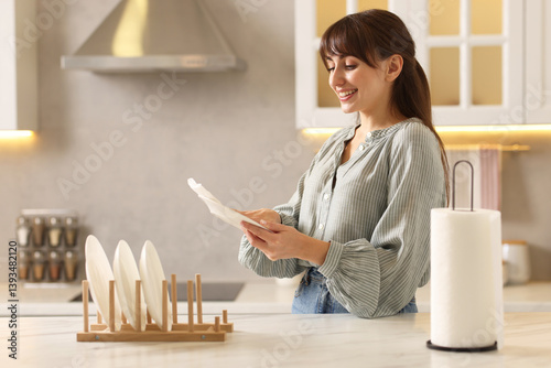 Obraz na płótnie Woman wiping plate with paper towel at white marble table in kitchen w salonie