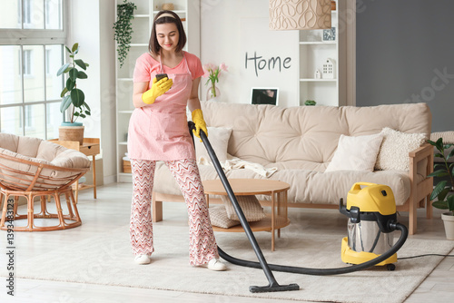Young woman cleaning carpet...