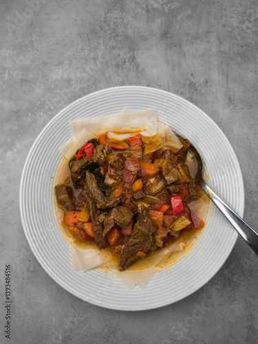 Hearty beef stew nestled alongside spongy injera, accompanied by bright vegetable medley highlighting ethiopian culinary traditions background wallpaper copy space