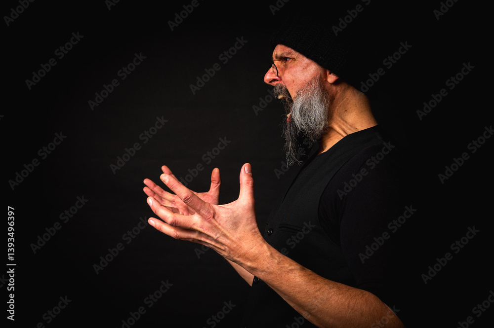 portrait, expressive mature man with sharp gaze and frowning face, wearing glasses and knitted hat, looking aside, screaming, facial expression. Dramatic portrait with strong emotions