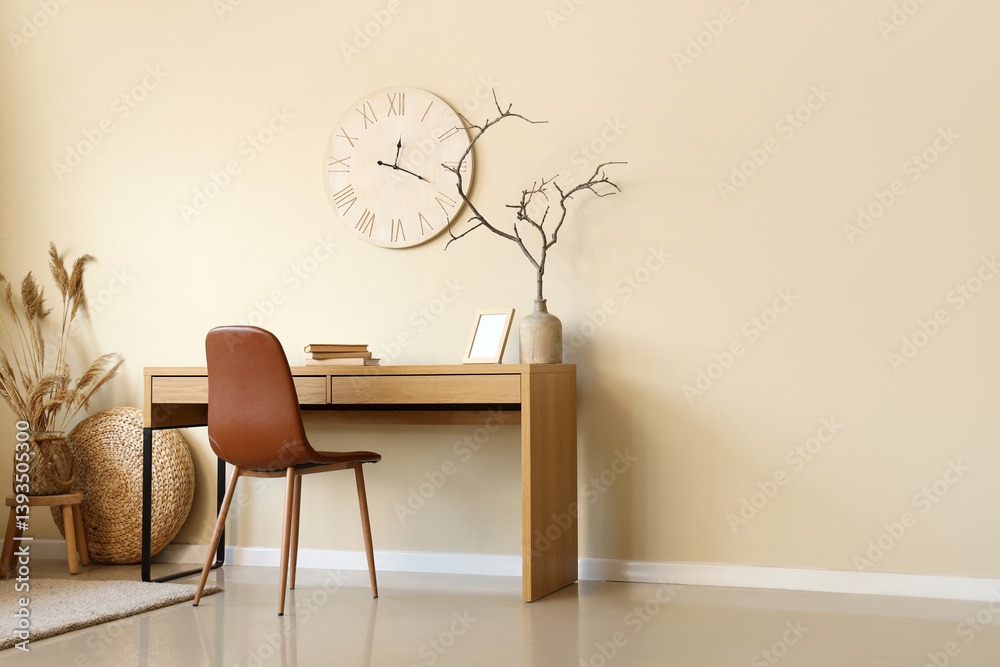 Stylish room with workplace, chair and clock on beige wall