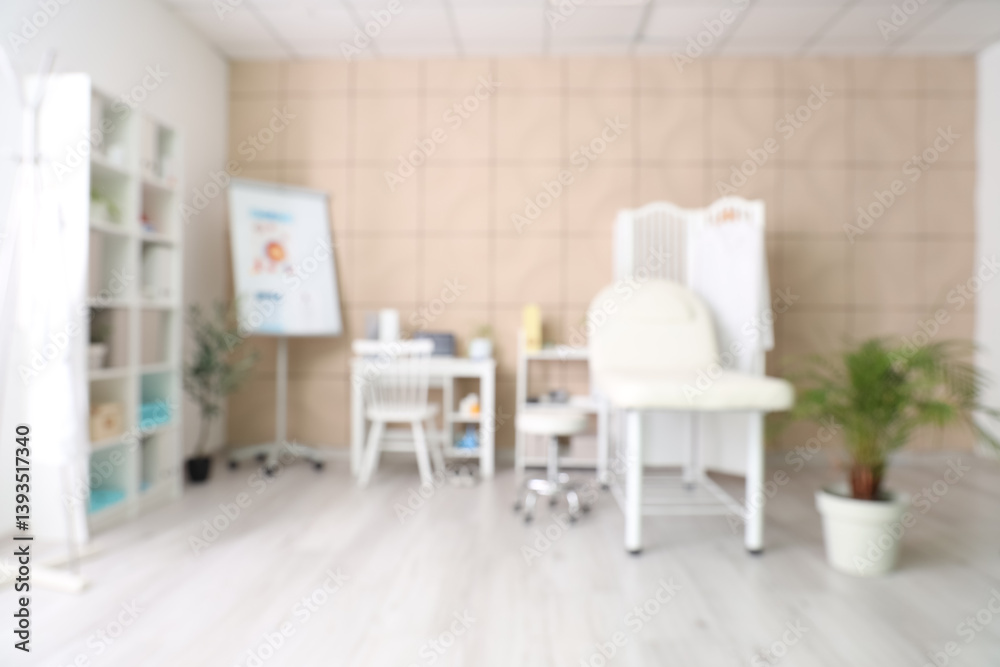 Blurred view of medical office with couch, folding screen and doctor's workplace Blurred view of medical office with couch, folding screen and doctor's workplace