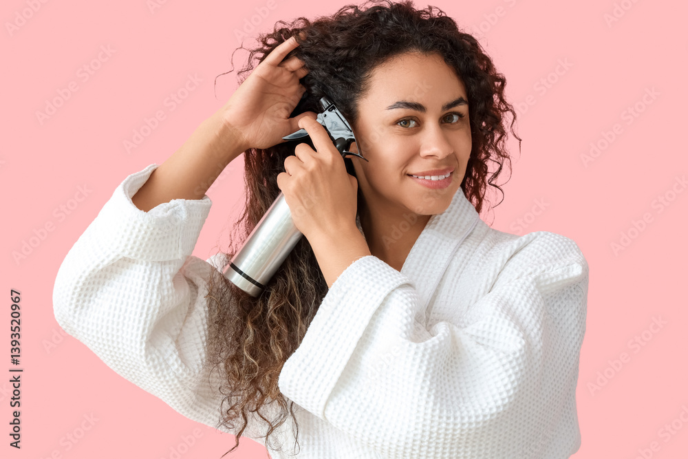 Beautiful young happy African-American woman with hair spray on pink background Beautiful young happy African-American woman with hair spray on pink background